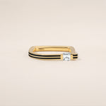 Gold ring with a diamond on a beige background