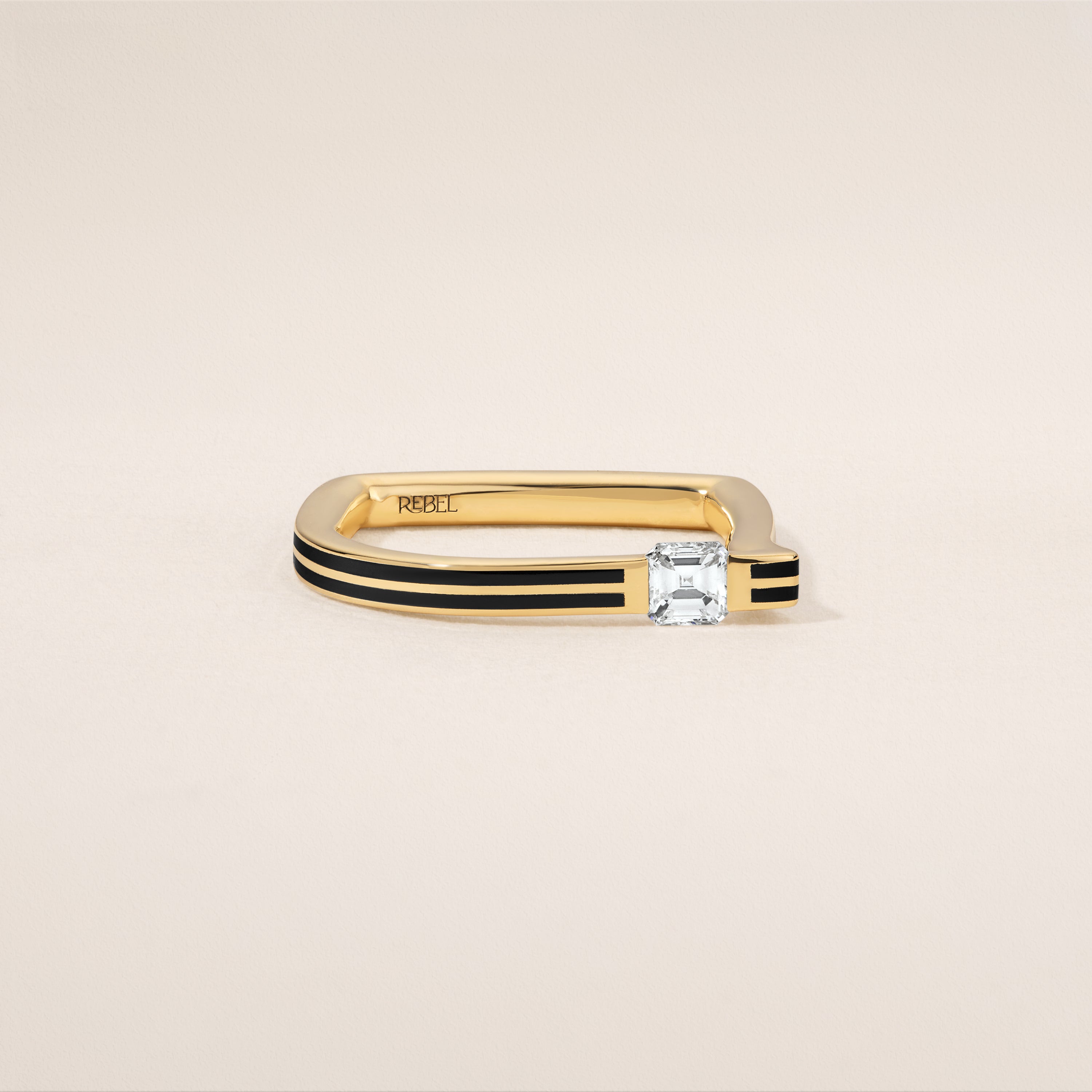 Gold ring with a diamond on a beige background