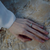 Hand with a ring on a textured stone surface
