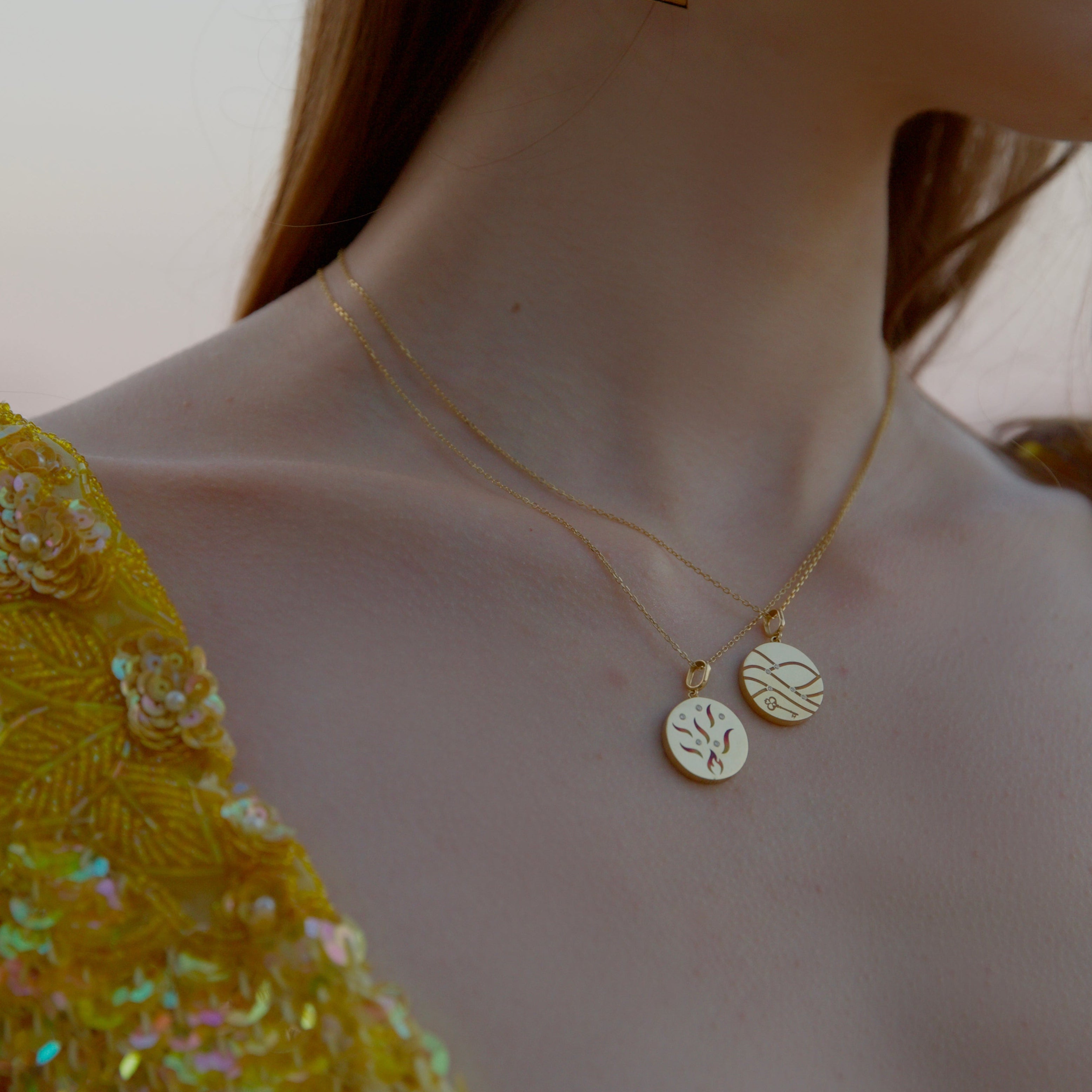 model wearing 18k gold fire and desert medallion charms from Rebel jewelry