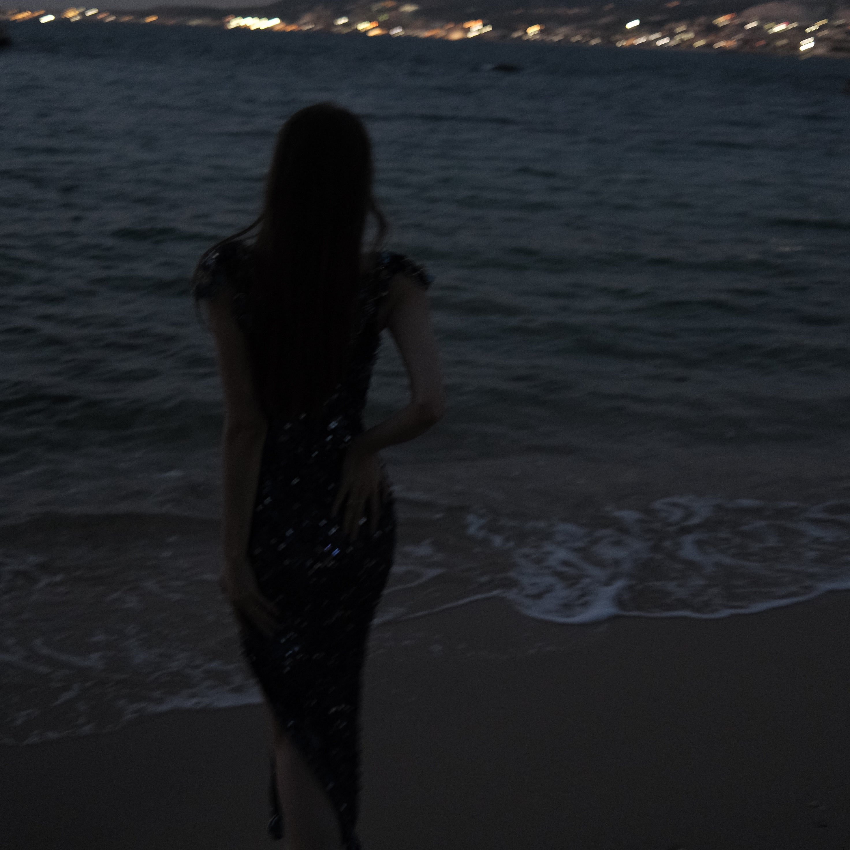 Silhouette of a person standing on a textured surface with a light source on the right.