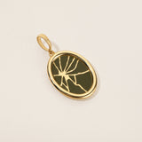 Gold pendant with a green stone on a beige background