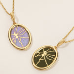 Two gold necklaces with oval pendants on a beige background