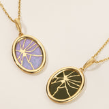 Two gold necklaces with oval pendants on a beige background